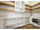 Spacious pantry featuring white cabinets, wooden shelving, and stainless steel microwave at 8021 Bud Morris Rd, Wake Forest, NC 27587