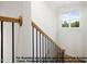 Bright staircase featuring wood handrail with black iron spindles and natural light from the window at 8021 Bud Morris Rd, Wake Forest, NC 27587