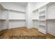 Spacious walk-in closet with custom shelving and wooden rods, complemented by a light hardwood floor at 8021 Bud Morris Rd, Wake Forest, NC 27587