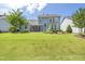 Wide backyard view with patio, outdoor kitchen, fire pit, and well-maintained lawn at 805 Narrative Ln, Durham, NC 27703
