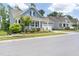 Beautifully landscaped blue home with a covered front porch, white railings, and a well-maintained lawn at 805 Narrative Ln, Durham, NC 27703