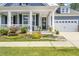 Charming home featuring a welcoming porch with white pillars, well-manicured landscaping, and a two-car garage at 805 Narrative Ln, Durham, NC 27703