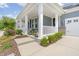 Charming front porch with white columns, black shutters, tasteful decor, and lush landscaping at 805 Narrative Ln, Durham, NC 27703