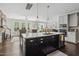Open-concept kitchen with dark island, stainless steel appliances, and seamless flow to the living area at 805 Narrative Ln, Durham, NC 27703