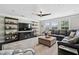 Bright living room with leather seating, decorative shelving and a ceiling fan at 805 Narrative Ln, Durham, NC 27703