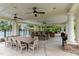 An outdoor kitchen and eating area is shown with ceiling fans and stone accents near the community pool at 805 Narrative Ln, Durham, NC 27703