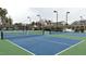Community tennis courts in blue and green are fenced and lit for gameplay at 805 Narrative Ln, Durham, NC 27703