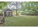 Backyard showcasing a synthetic lawn, shed, deck, screened porch and mature trees at 813 Burch Ave, Durham, NC 27701