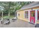 Charming backyard with a wooden deck, outdoor seating, and a yellow house facade at 813 Burch Ave, Durham, NC 27701
