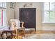 Inviting room featuring a wooden armoire, stylish chair, and a decorative rug on hardwood floors at 813 Burch Ave, Durham, NC 27701