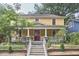 Charming yellow two-story home with a welcoming front porch and landscaped yard at 813 Burch Ave, Durham, NC 27701