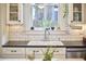 Close-up of the sink area, showcasing subway tile, and plants in front of the bright window at 813 Burch Ave, Durham, NC 27701