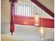 View of the red and white staircase with hanging jar lights and natural light at 813 Burch Ave, Durham, NC 27701