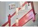 View of the red and white staircase with hanging jar lights and natural light at 813 Burch Ave, Durham, NC 27701