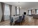 Formal dining room with wood floors, chandelier, and stylish grey chairs and matching window treatments at 825 Abbyberry Dr, Wake Forest, NC 27587
