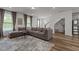 Spacious living room with neutral tones, large sectional sofa, accent rug, and wood-look flooring at 825 Abbyberry Dr, Wake Forest, NC 27587