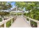 Scenic view of a lakeside pavilion with seating, accessible via a wooden walkway at 825 Abbyberry Dr, Wake Forest, NC 27587