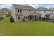 The rear of the home features a screened-in porch overlooking the grassy backyard and wooded area at 831 Poplar St, Durham, NC 27703