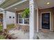Cozy front porch area with seating for two; fern and dark entry door at 831 Poplar St, Durham, NC 27703