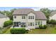Back of house, including screened in porch with a deck area, mature landscaping and a multi-level yard at 9013 Dansforeshire Way, Wake Forest, NC 27587