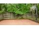 Basketball court featuring a traditional hoop surrounded by a tall fence and lush greenery at 9013 Dansforeshire Way, Wake Forest, NC 27587