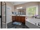 Bright bathroom with a soaking tub, dark wood cabinets and black tile flooring at 9013 Dansforeshire Way, Wake Forest, NC 27587