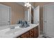 Dual sink vanity with dark wood cabinets and large mirror with bright lighting at 9013 Dansforeshire Way, Wake Forest, NC 27587