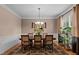 Classic dining room featuring a wooden table, six chairs, and a decorative chandelier and carpet at 9013 Dansforeshire Way, Wake Forest, NC 27587
