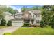 Attractive two-story home with stone and siding, a manicured lawn, and attached garage at 9013 Dansforeshire Way, Wake Forest, NC 27587