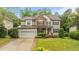 Charming two-story home with a stone and siding exterior and well-manicured lawn at 9013 Dansforeshire Way, Wake Forest, NC 27587