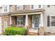 Cozy front porch featuring stone accents, black railings, and a seating area at 9013 Dansforeshire Way, Wake Forest, NC 27587