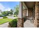 Covered front porch showcases stone detailing, black iron railings, and an outdoor sitting area at 9013 Dansforeshire Way, Wake Forest, NC 27587