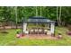 Backyard aerial view of a covered gazebo featuring a dining table set, stone base and surrounding greenery at 9013 Dansforeshire Way, Wake Forest, NC 27587