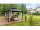 Backyard with a covered gazebo featuring a dining table set, stone base and surrounding greenery for serene outdoor dining at 9013 Dansforeshire Way, Wake Forest, NC 27587