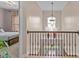 Hallway with a wrought iron banister and hanging light fixture at 9013 Dansforeshire Way, Wake Forest, NC 27587