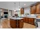 Open kitchen with large center island, granite countertops, and wooden cabinetry at 9013 Dansforeshire Way, Wake Forest, NC 27587