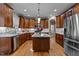 Open kitchen with stainless appliances, granite countertops, center island and wooden cabinetry at 9013 Dansforeshire Way, Wake Forest, NC 27587