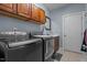 Modern laundry room with stainless steel appliances, a sink, and overhead cabinetry at 9013 Dansforeshire Way, Wake Forest, NC 27587