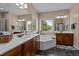 Luxurious primary bathroom with double sinks, large soaking tub and a view to outside at 9013 Dansforeshire Way, Wake Forest, NC 27587