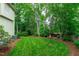 Spacious backyard featuring a lush lawn, mature trees, and inviting outdoor seating at 102 Lions Mouth Ct, Cary, NC 27518