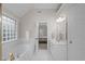 Bright bathroom features a soaking tub, white vanity, and an open doorway to the bedroom at 102 Lions Mouth Ct, Cary, NC 27518