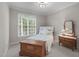 Cozy bedroom with a full bed, wooden chest, dresser, and bright natural light from the large window at 102 Lions Mouth Ct, Cary, NC 27518