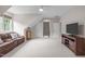 Bonus room featuring carpet floors, an entertainment center and a brown leather sofa at 102 Lions Mouth Ct, Cary, NC 27518