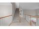 Upstairs hallway with carpet flooring, white banisters and wooden handrail, leading to bedrooms at 102 Lions Mouth Ct, Cary, NC 27518