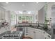 Spacious kitchen with white cabinetry, granite countertops, stainless steel appliances, and an adjoining sunlit dining area at 102 Lions Mouth Ct, Cary, NC 27518