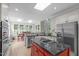 Open-concept kitchen with a red island, stainless steel appliances, granite countertops, and a dining area with abundant natural light at 102 Lions Mouth Ct, Cary, NC 27518