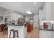 Well-lit kitchen featuring a red island cooktop, white cabinetry, granite countertops, and stainless steel appliances at 102 Lions Mouth Ct, Cary, NC 27518