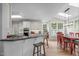 Bright kitchen featuring white cabinets, a granite countertop bar, and an adjacent dining area with natural light at 102 Lions Mouth Ct, Cary, NC 27518
