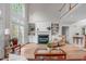 Spacious living room with fireplace, built-in shelving, and two-story windows to let in natural light at 102 Lions Mouth Ct, Cary, NC 27518