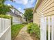 Landscaped backyard with a stone pathway and white picket fence, creating a serene and private outdoor space at 102 Westside Dr, Chapel Hill, NC 27516
